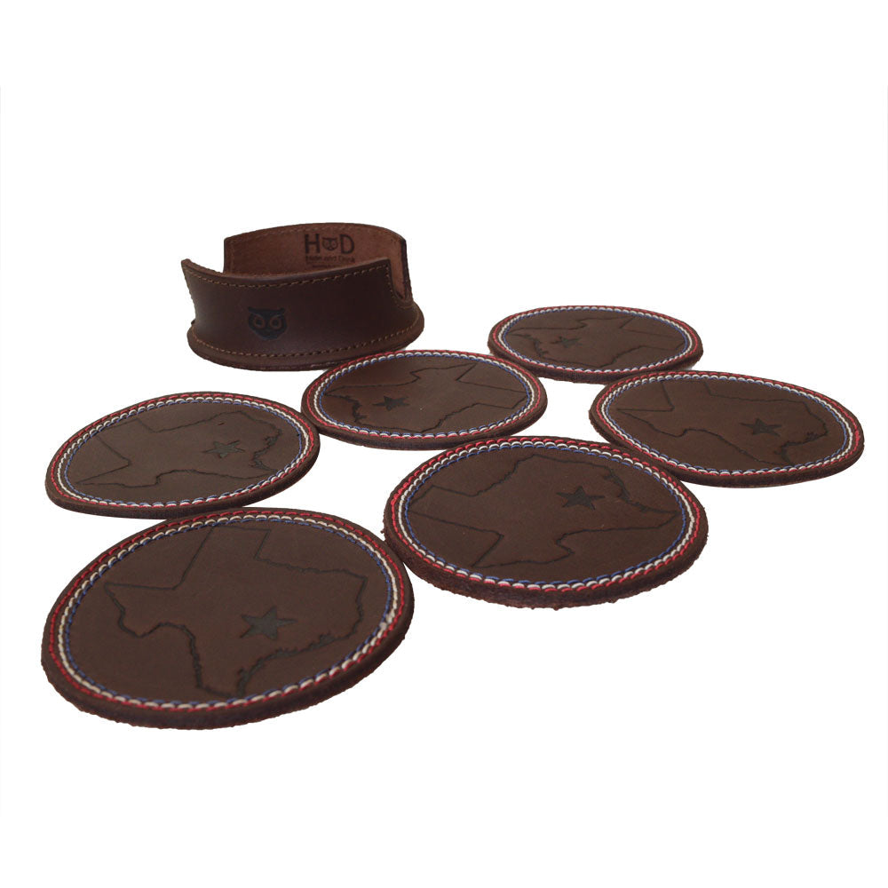 Texas State Coasters with Stitching (6-Pack) by Hide & Drink arranged with 6 leather coasters and a holder, showcasing the Texas state design. Perfect for protecting your furniture from drink stains. Set of 6 Coasters for Drinks with Texas State Design, Glass and Cups Stain Protection, Full Grain Leather, StockyardX, Small Batch Production, Hand Cut, Hand Sewn, Fire Branded, Artisan, Handmade in La Antigua Guatemala & Oaxaca Mexico.