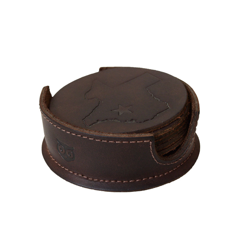 The Texas State Coasters (6-Pack) by Hide & Drink displayed in a practical coaster holder, made from Durable Thick Leather. Ideal for your living room decor, these coasters boast Lone Star Coasters Without Stitching, highlighting the artisan nature of this handmade product from La Antigua Guatemala & Oaxaca Mexico.