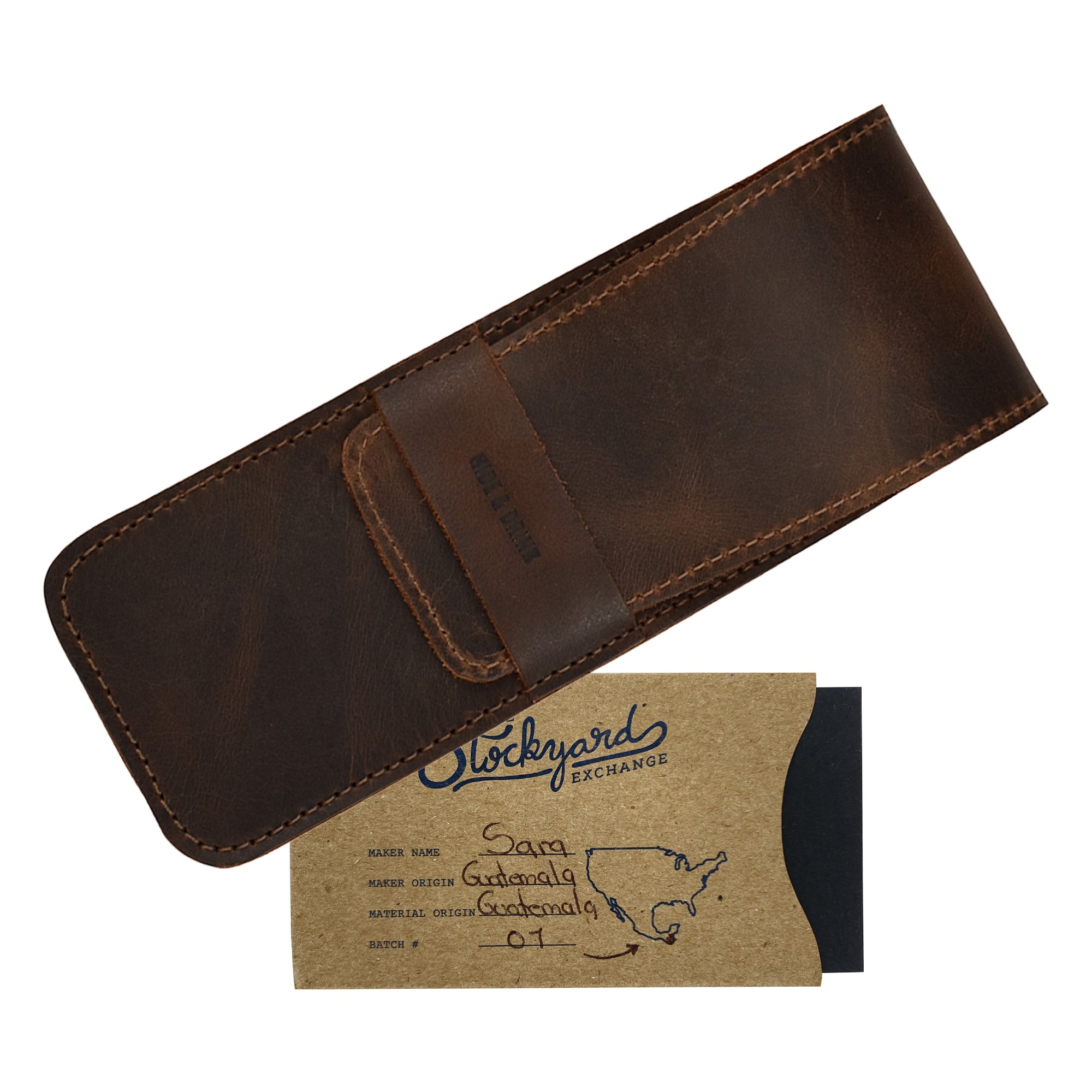 An image of the Hide & Drink Pen Case alongside a business card, showcasing its elegant design. This Pen Case Holder serves as a Multi Pen Pouch for storing writing instruments. Made from premium Full Grain Leather, it highlights StockyardX's emphasis on small batch production. The hand cut and hand sewn details are complemented by the fire branded logo, marking it as an artisan product, handmade in La Antigua Guatemala & Oaxaca Mexico.