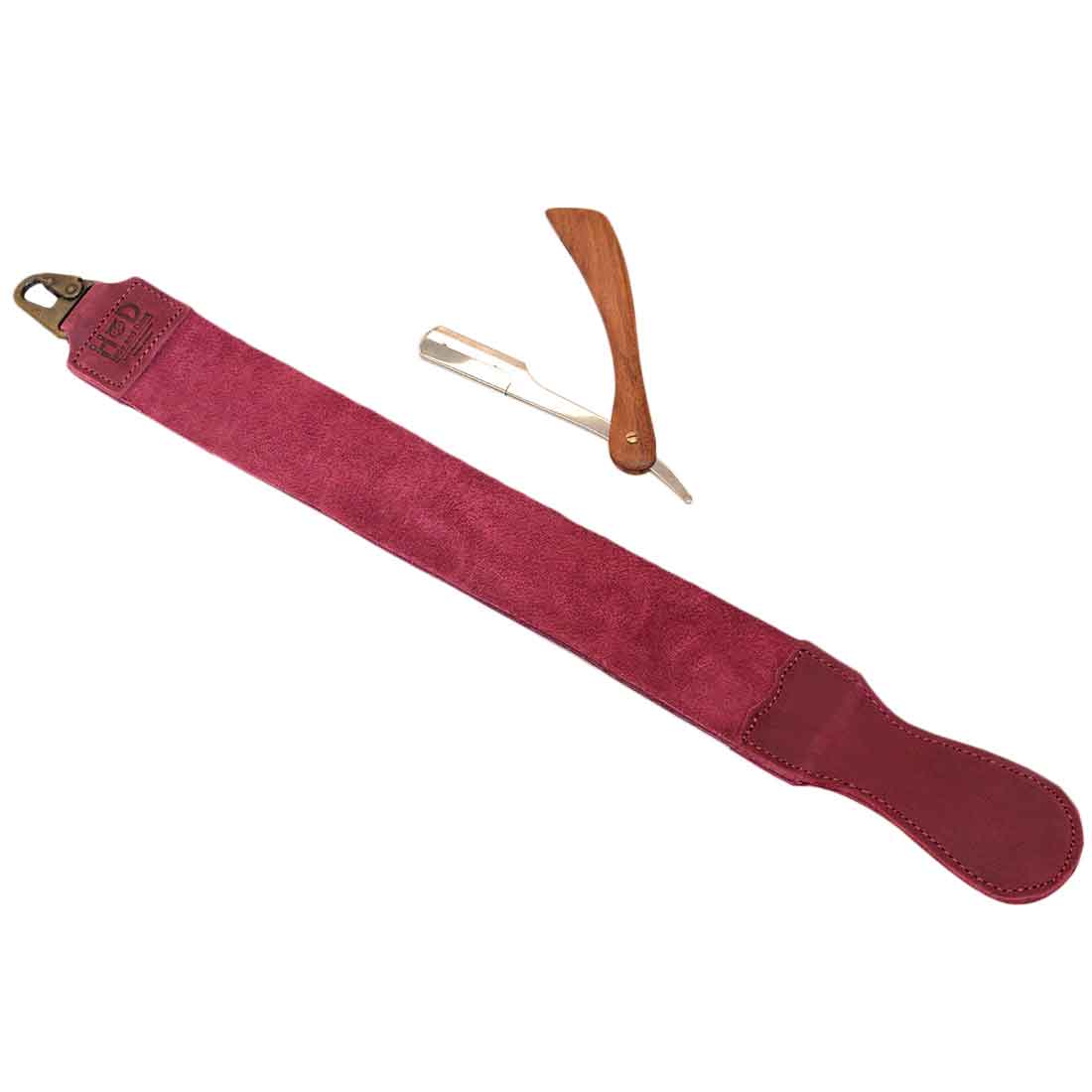Hide & Drink's purple Barber Strop displayed with a razor, emphasizing its professional-grade quality. This Full Grain Leather shaving sharpener functions well as a Razor Strop and highlights artisan production.
