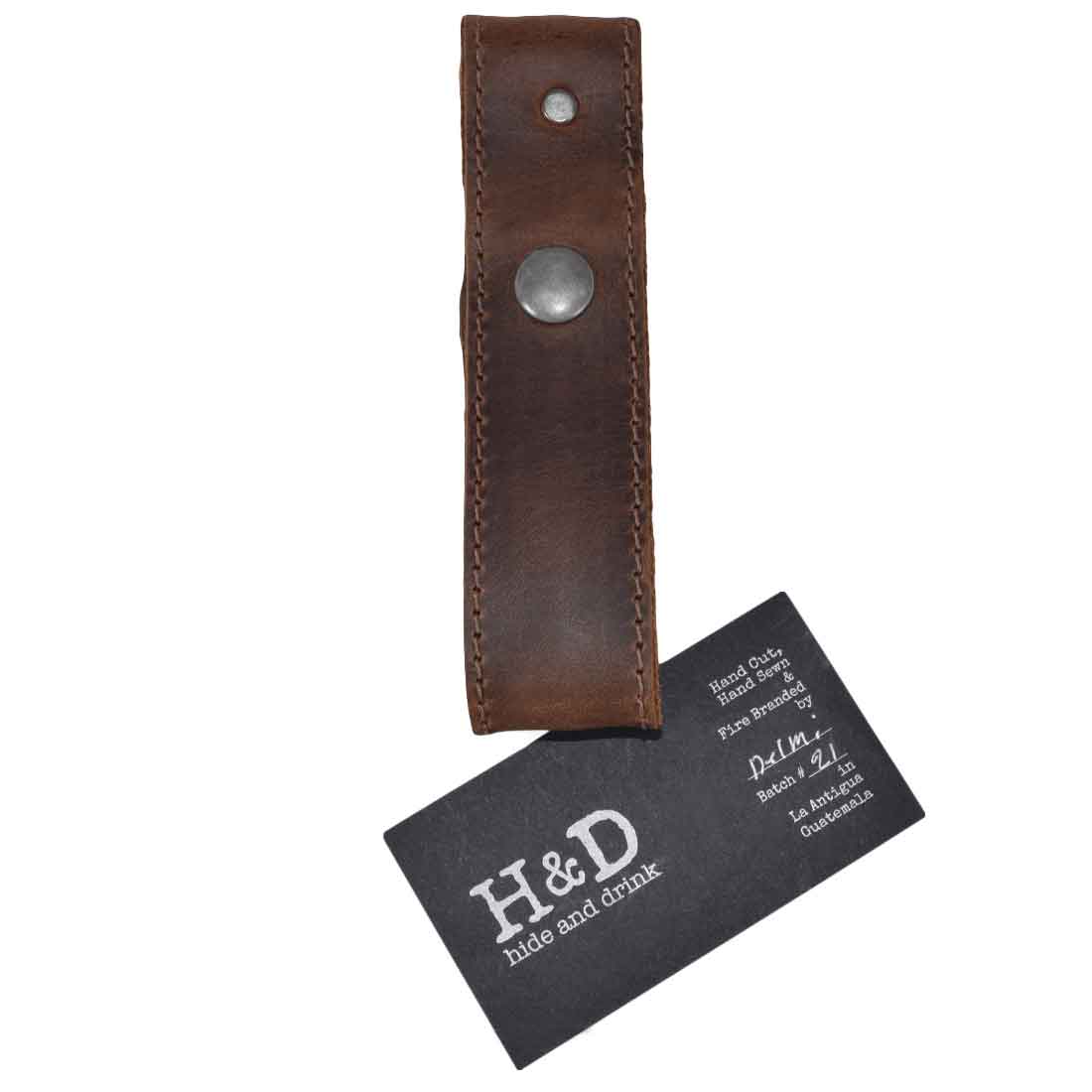 Hide & Drink Whip Holster seen with a stylish business card, emphasizing its artisan and handmade quality. This unique Bullwhip Holder is crafted from Full Grain Leather, representing Small Batch Production and the skilled handiwork typical of the exquisite Hide & Drink collection from La Antigua Guatemala & Oaxaca Mexico.