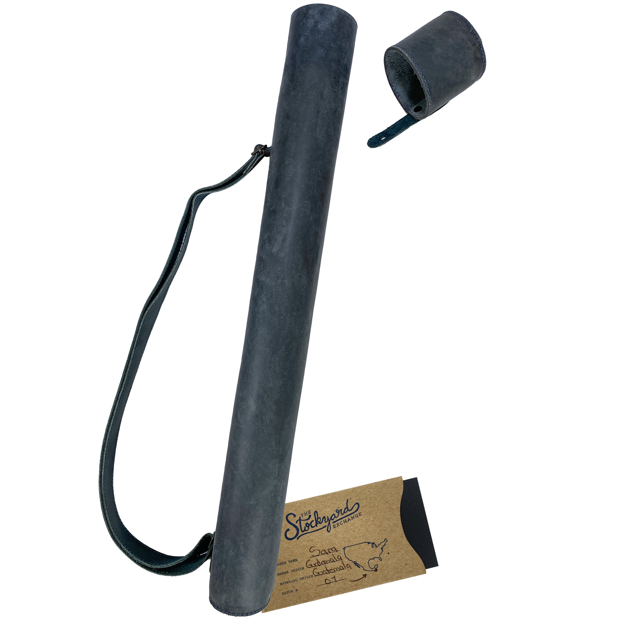 Hide & Drink's Blueprint Tube (A2 Paper Size) shown alongside black architectural plans. This full grain leather document storage tube with an adjustable strap is perfect for architects, illustrating StockyardX's artisan quality and handmade skills from La Antigua Guatemala & Oaxaca Mexico.
