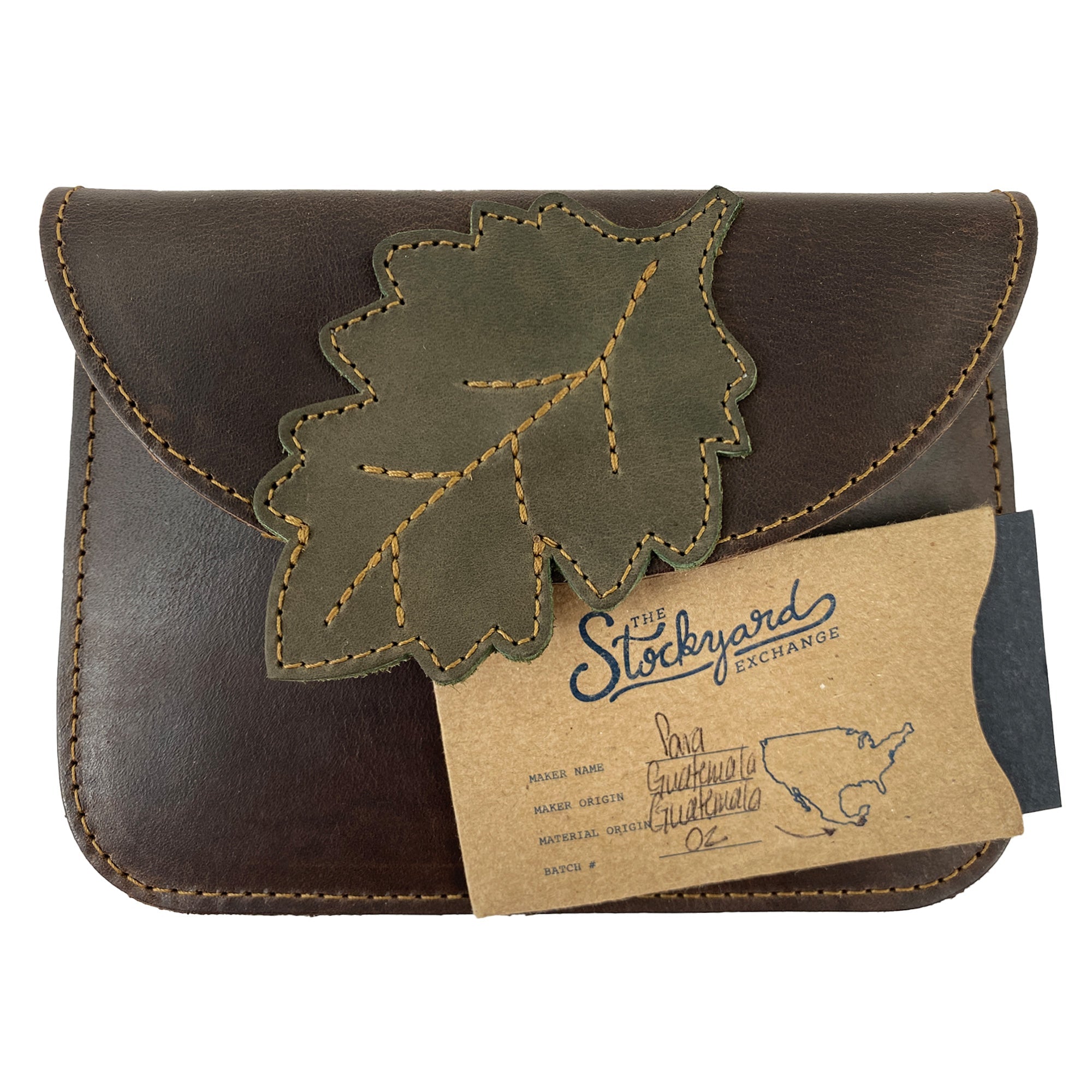 Front view of Heather's Leaf Card Wallet accompanying a tag that indicates its handmade origin. This Leaf Card Wallet combines functionality as a soft coin & cash organizer, cable holder, or phone & accessories case, emphasizing its artisanal qualities from La Antigua Guatemala and Oaxaca Mexico.