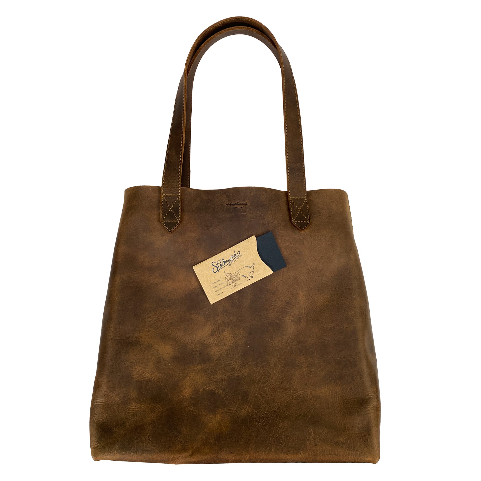 Heather's Classic Tote Bag with a stylish tag and card, emphasizing its identity as a vintage style purse made from full grain leather. This handmade item is perfect for those who appreciate artisan craftsmanship in La Antigua Guatemala.