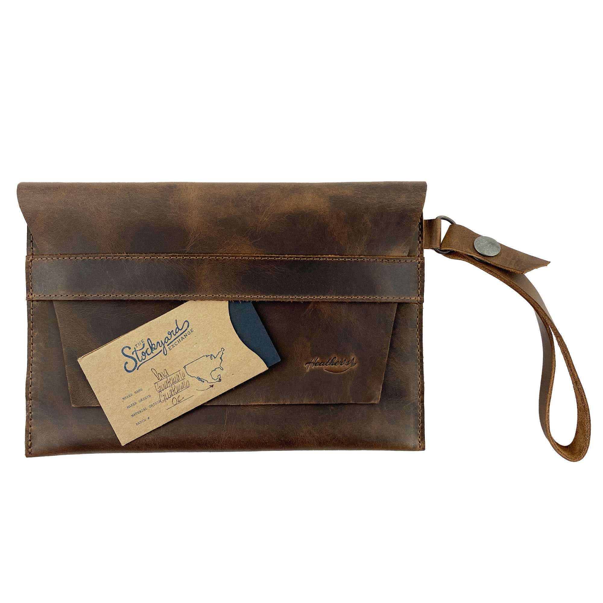 Heather's Vintage Clutch Bag shown with a business card, emphasizing its stylish wrist wallet design for cards and money. Made from premium full grain leather, this artisan bag highlights the careful craftsmanship involved in small batch production in La Antigua Guatemala & Oaxaca Mexico.