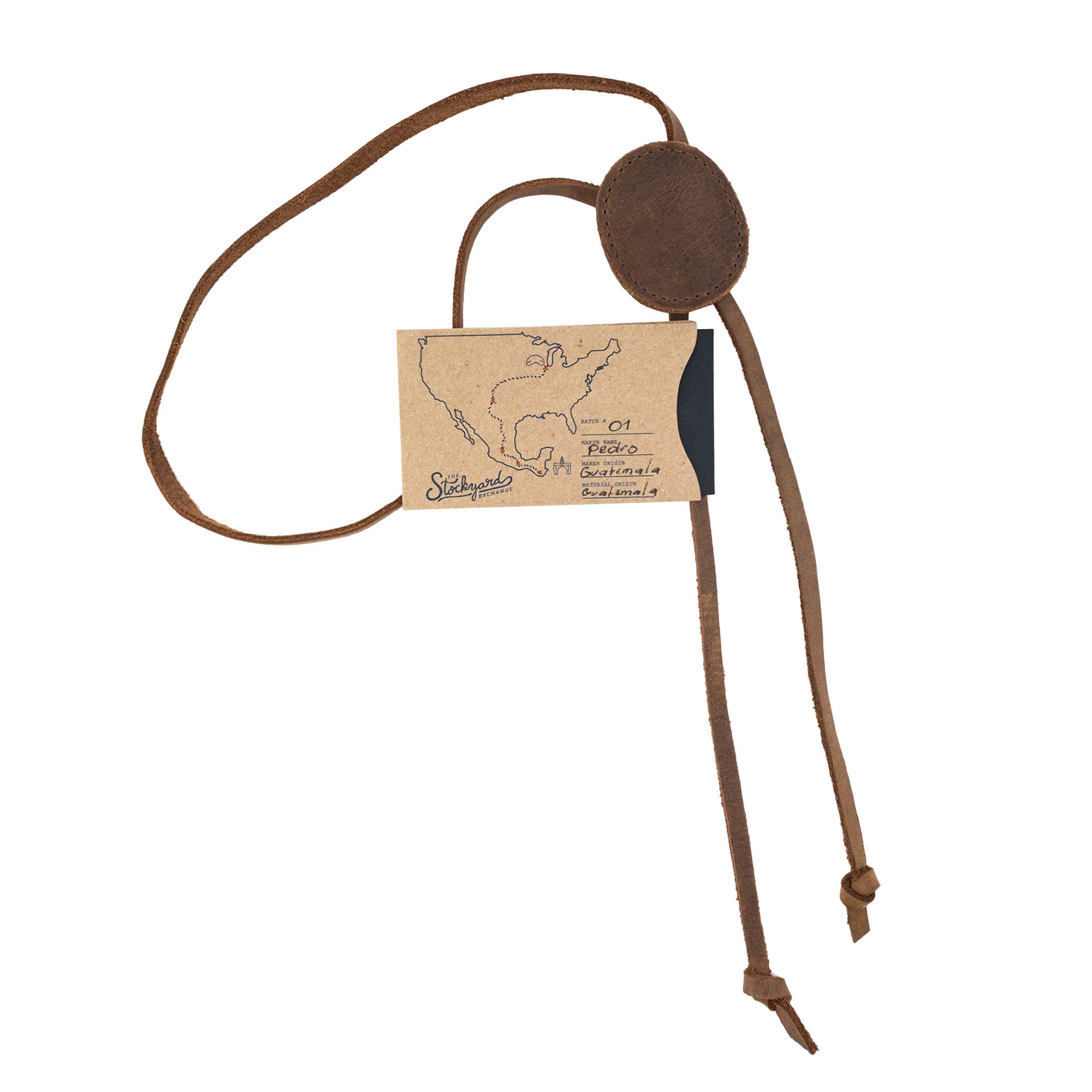Cowboy Bolo Tie from Western Leather Works presented with a tag, emphasizing its round shape and full grain leather construction. This handmade necktie costume accessory represents artisan craftsmanship through small batch production in La Antigua Guatemala & Oaxaca Mexico.