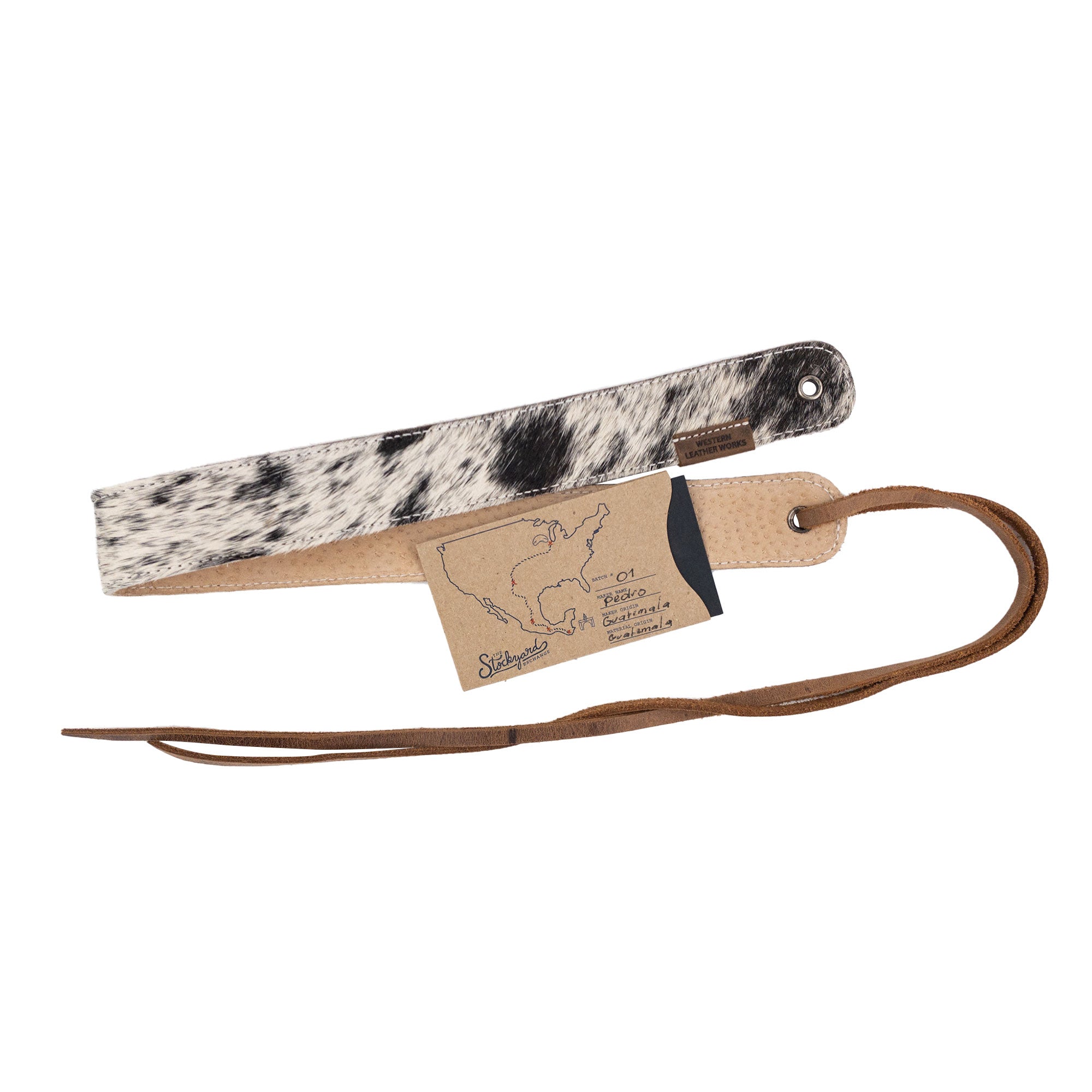 Cowboy Hatband with a tag by Western Leather Works, featuring Hair-On-Hide Full Grain Leather. This adjustable accessory for cowboy hats represents rodeo style and is handcrafted in La Antigua Guatemala, highlighting the small batch production values, including hand cut, hand sewn workmanship and fire branding by skilled artisans.