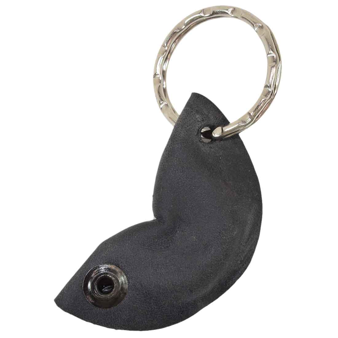 A close look at the Fidget Cashew Keychain by Hide & Drink, featuring a smooth black finish. This charming key holder serves as a Good Luck Charm, made from durable Full Grain Leather. The piece highlights small batch production and artisan craftsmanship, with designs that are hand cut, hand sewn, and fire branded in La Antigua Guatemala and Oaxaca Mexico.