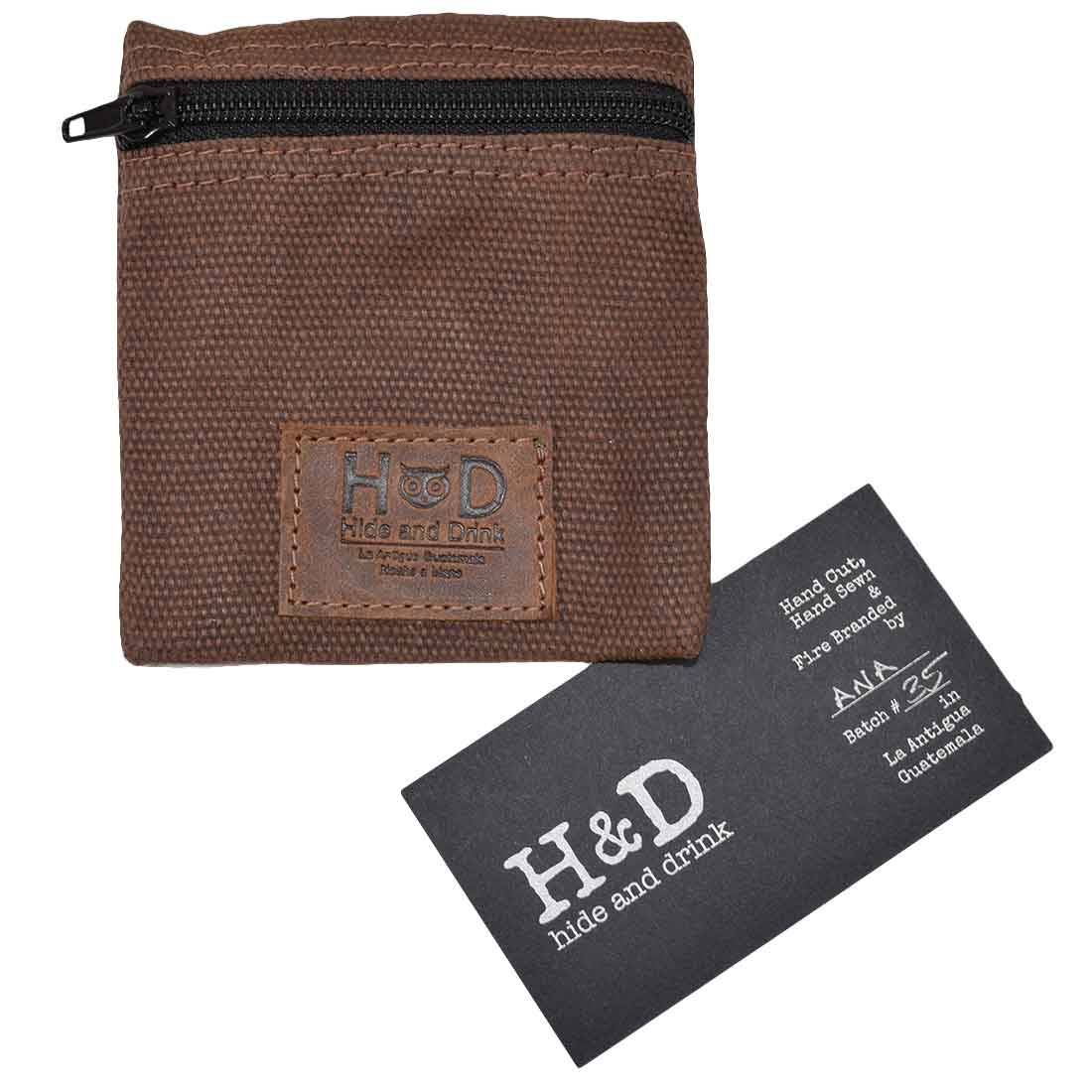 Hide & Drink Condom Pouch alongside a branding card, emphasizing its high-quality water resistant waxed canvas. This versatile pouch makes an ideal classic partner gift and travel essential. Handmade by artisans in La Antigua Guatemala reflects skilled craftsmanship in small batch production.