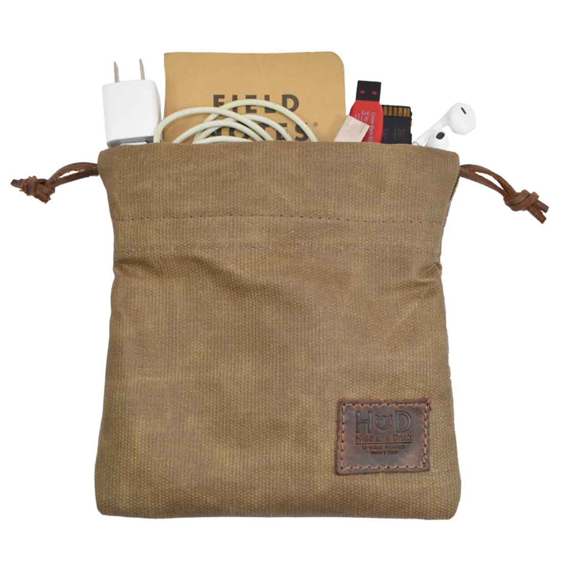 The Hide & Drink Golf Pouch filled with tech accessories, ideal for keeping cables organized for golfers on the go. This stylish waxed canvas pouch is a must-have for your golf bag. Waxed Canvas Golf Valuables Field Pouch, Golf Bag, Sport Organizer, Multipurpose Pouch with String, StockyardX, Small Batch Production, Hand Cut, Hand Sewn, Fire Branded, Artisan, Handmade in La Antigua Guatemala & Oaxaca Mexico.