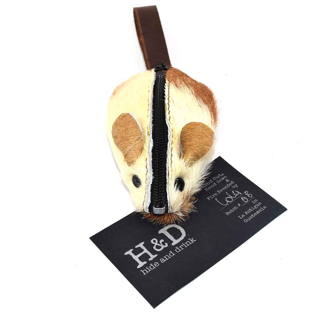 Showcasing the Hide & Drink Mouse Coin Pouch, accompanied by its tag, exemplifies the attention to detail in this handmade product. This mouse-shaped change pouch, crafted from full grain leather, combines functionality with artful design, making it an excellent travel accessory.