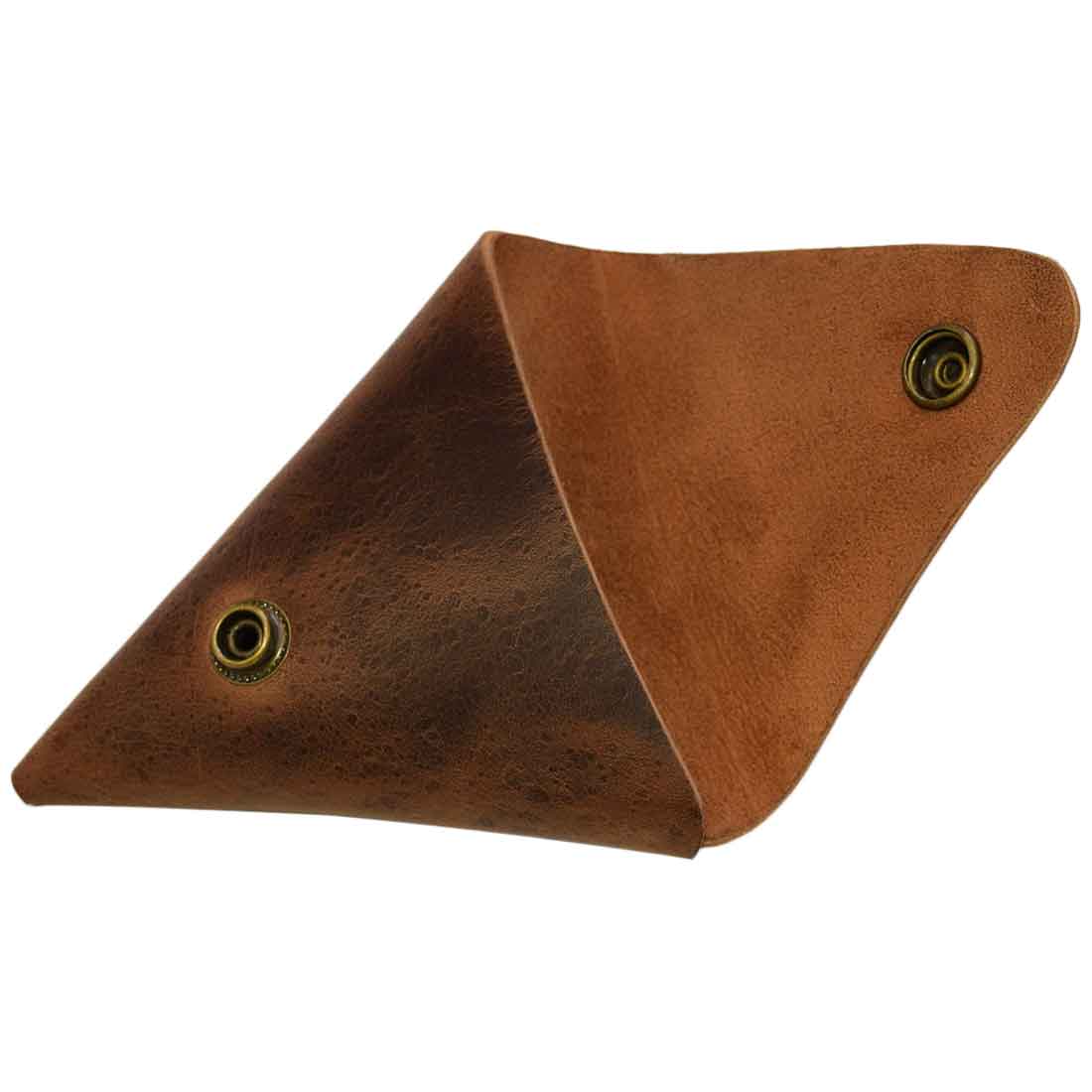 An artistic angle of the Triangle Coin Pouch from Hide & Drink, illustrating its sleek design. This Triangle Coin Pouch, made from Full Grain Leather, serves as a versatile holder for cash, USB flash drives, and more. Experience artisan craftsmanship with this handmade pouch, hand cut and fire branded in La Antigua Guatemala & Oaxaca Mexico.