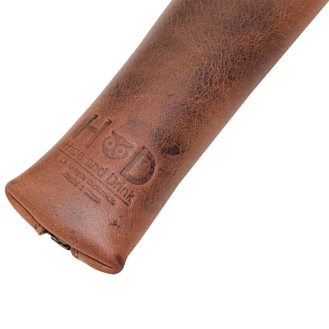 Close up of the Hide & Drink Long Coin Organizer showcasing its fire branded logo and premium craftsmanship. This elegant Long Coin Case acts as a Cash Holder and Rustic Case for Pennies, also serving as a Vintage Zippered Pouch. Composed of full grain leather, this item is a result of Small Batch Production, showcasing Hand Cut and Hand Sewn design aspects crafted by artisans from La Antigua Guatemala & Oaxaca Mexico.