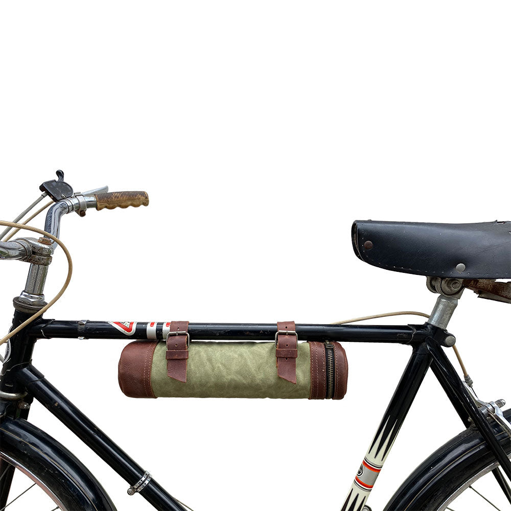 A bicycle adorned with the Bicycle Tube from Hide & Drink, ideal for transporting drinks with style. This Zipper Commute Bag not only serves practical purposes but showcases the beauty of full grain leather and artisan craftsmanship. Handmade in La Antigua Guatemala and Oaxaca Mexico.